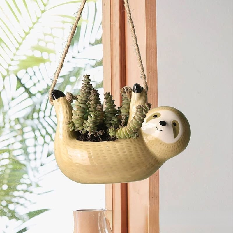Charming ceramic sloth planter, a whimsical hanging pot for indoor/outdoor plants & succulent arrangements.