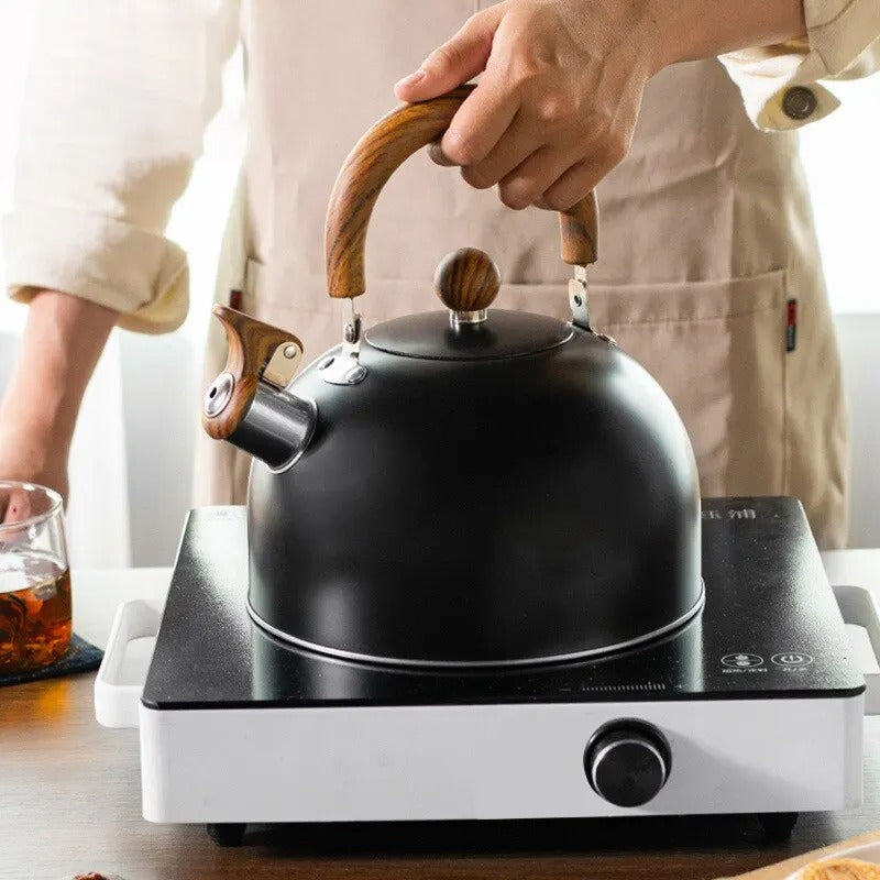 Modern whistling tea kettle in polished stainless steel with an ergonomic, heat-resistant handle for tea.