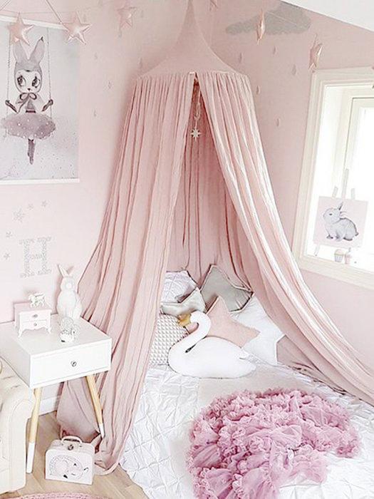 White baby nursery bed canopy creating a magical, cozy sleep & play space for a child's room.
