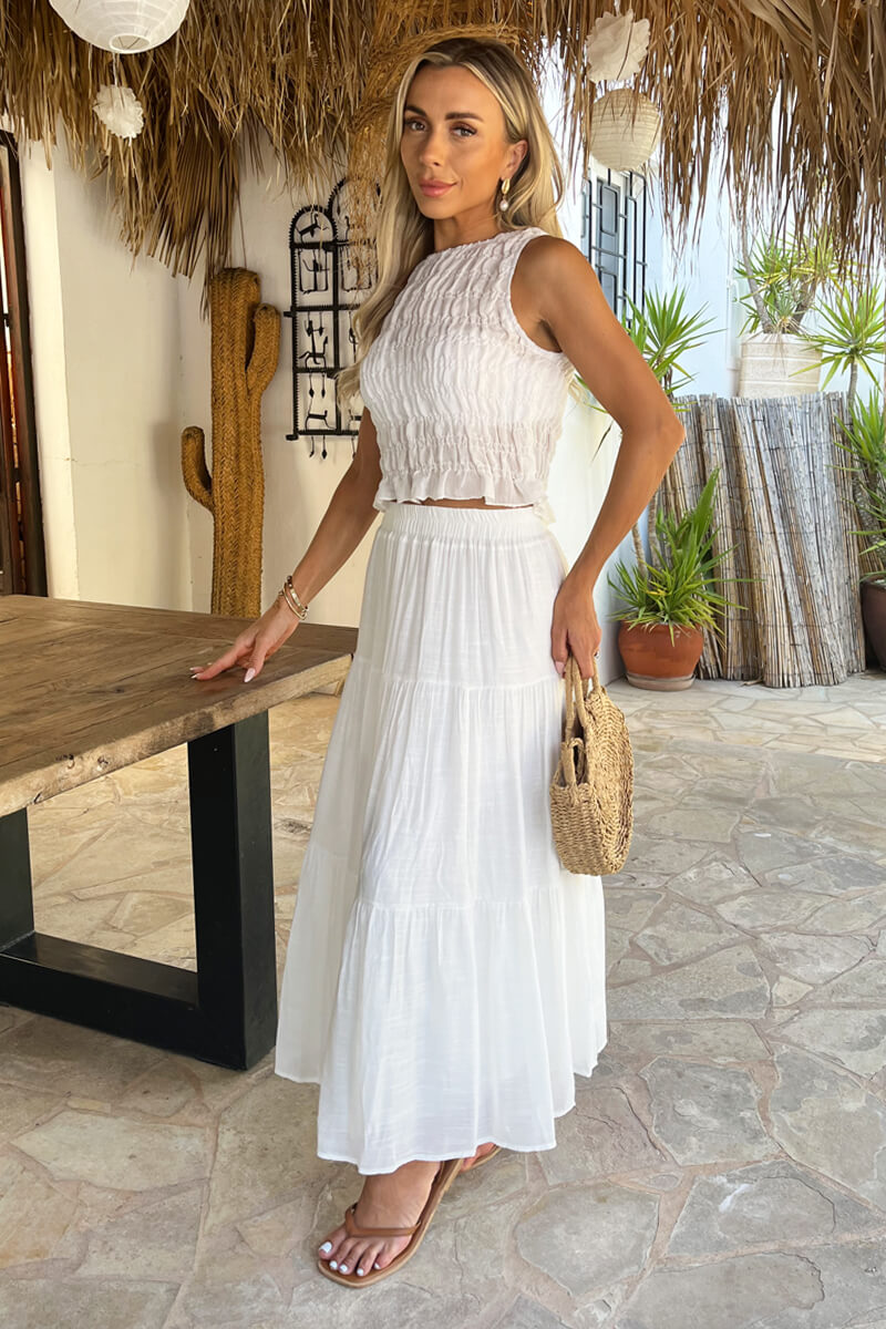 Close-up of the flowy white tiered midi skirt fabric, highlighting its elegant summer design.