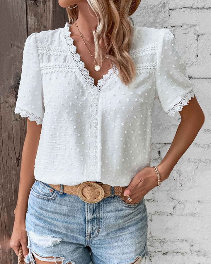 Women's V-neck summer blouse featuring beautiful lace trim. A versatile and comfortable short-sleeve top.