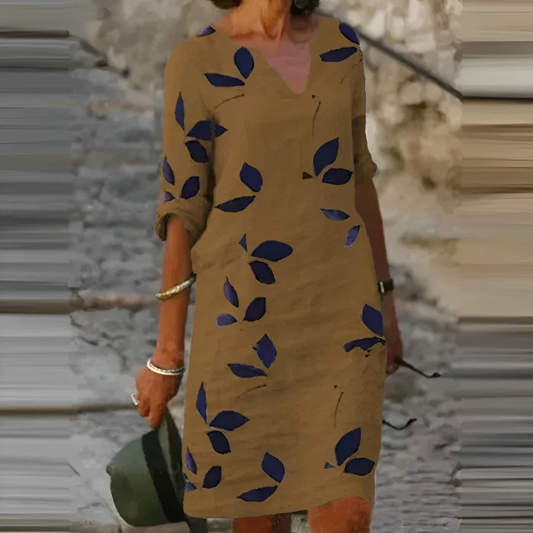 White women's sleeveless midi summer dress with elegant green leaf print, perfect for beach or casual vacation wear.
