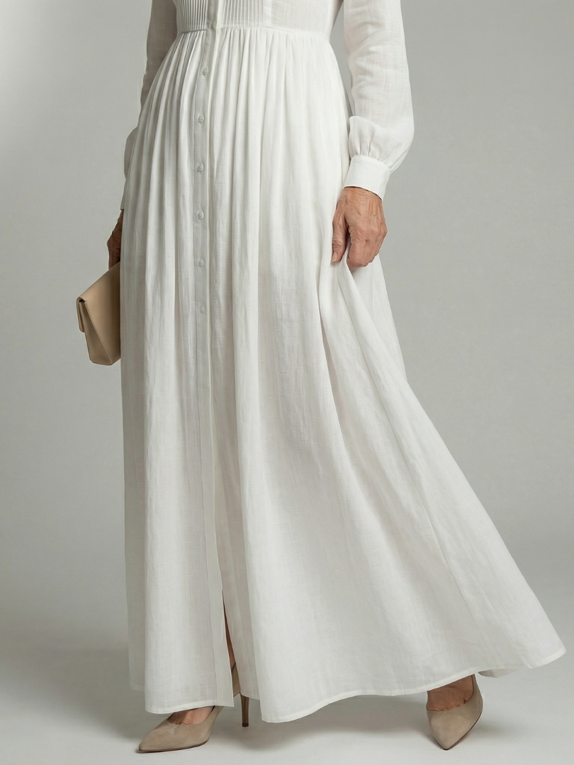Elegant casual white maxi dress for women. Features long sleeves, gathered waist, & button front. Ideal for everyday spring/summer.