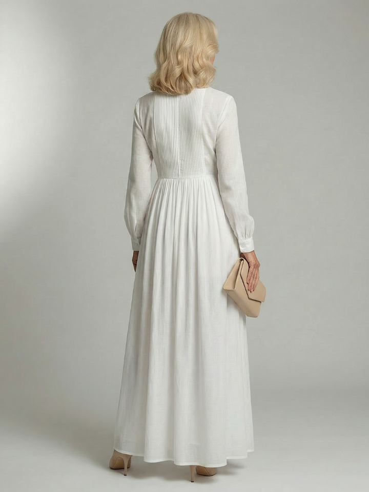 Women's white flowing long sleeve maxi dress. Soft fabric & gathered waist offer comfort & style for versatile spring fashion.
