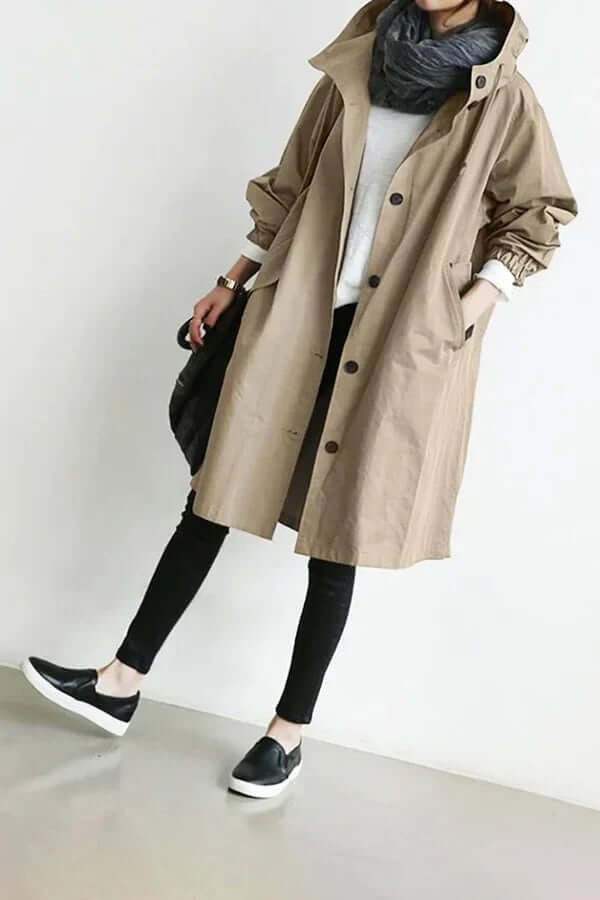 Fashionable woman wearing a modern lightweight rain cape, staying dry and chic in wet weather.