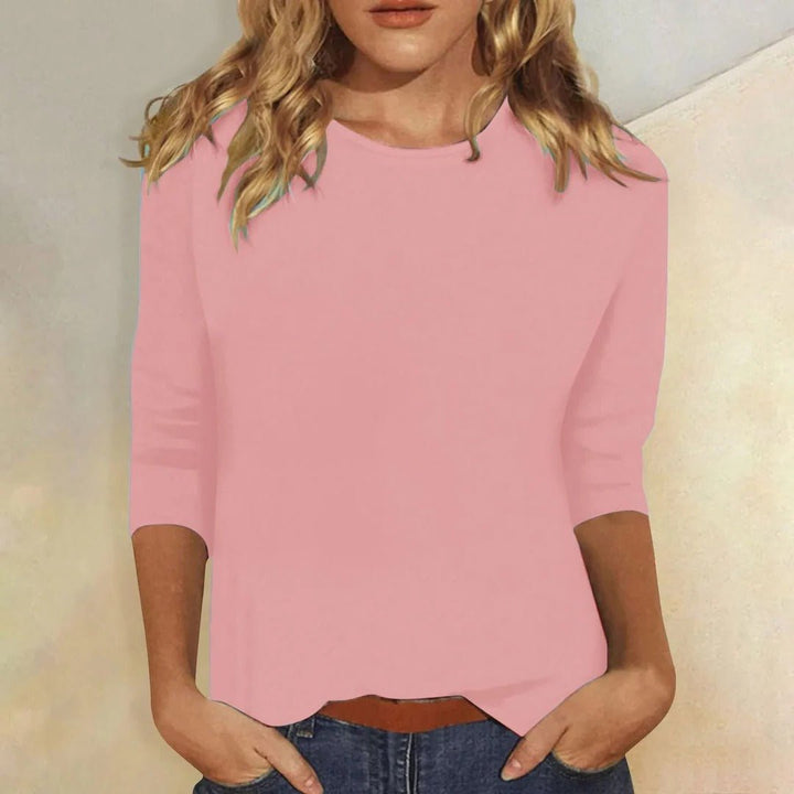 Woman models a relaxed fit 3/4 sleeve crew neck top in soft fabric, perfect for casual everyday style.