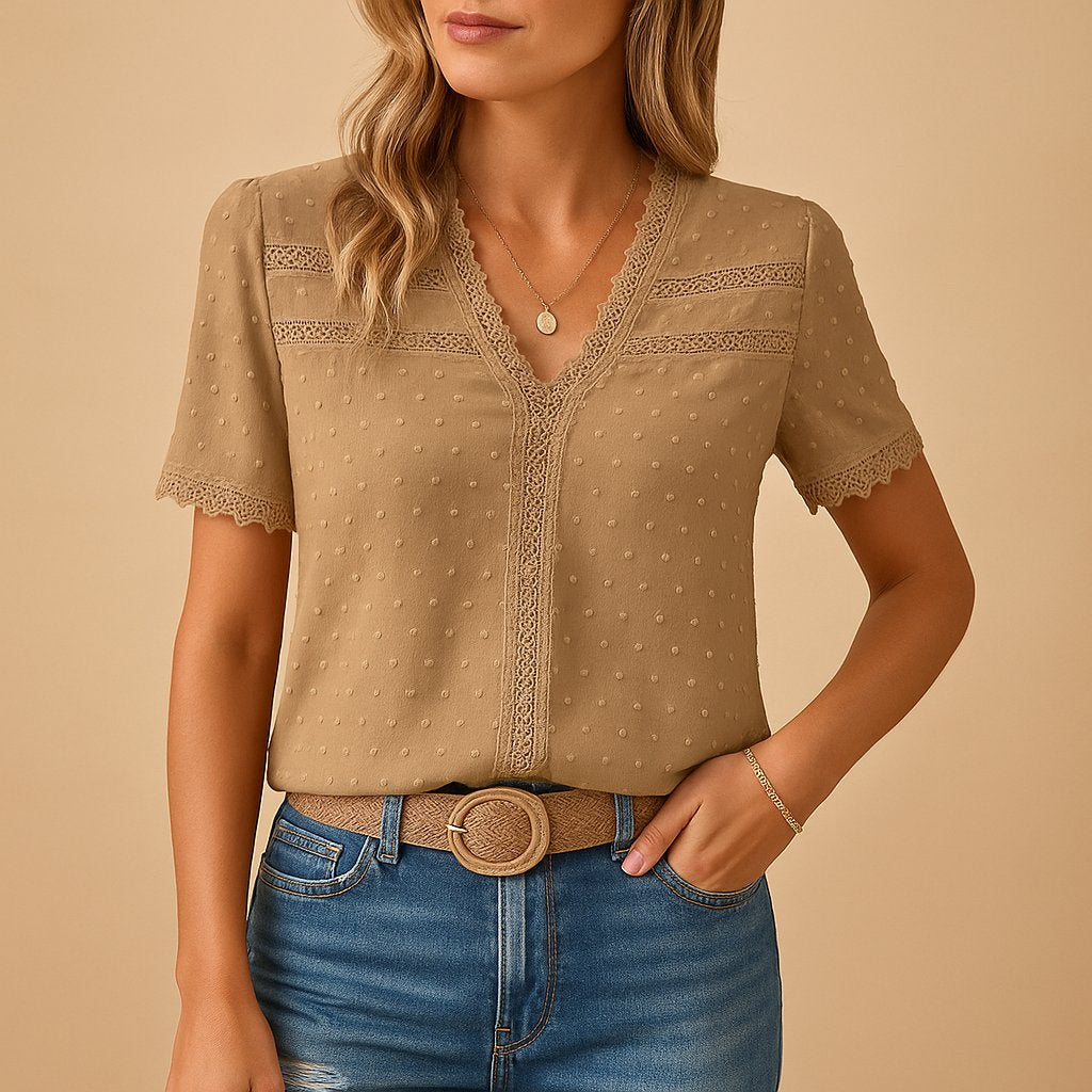 Woman's elegant V-neck blouse with delicate lace trim, textured dot pattern & short sleeves, perfect for office or casual.
