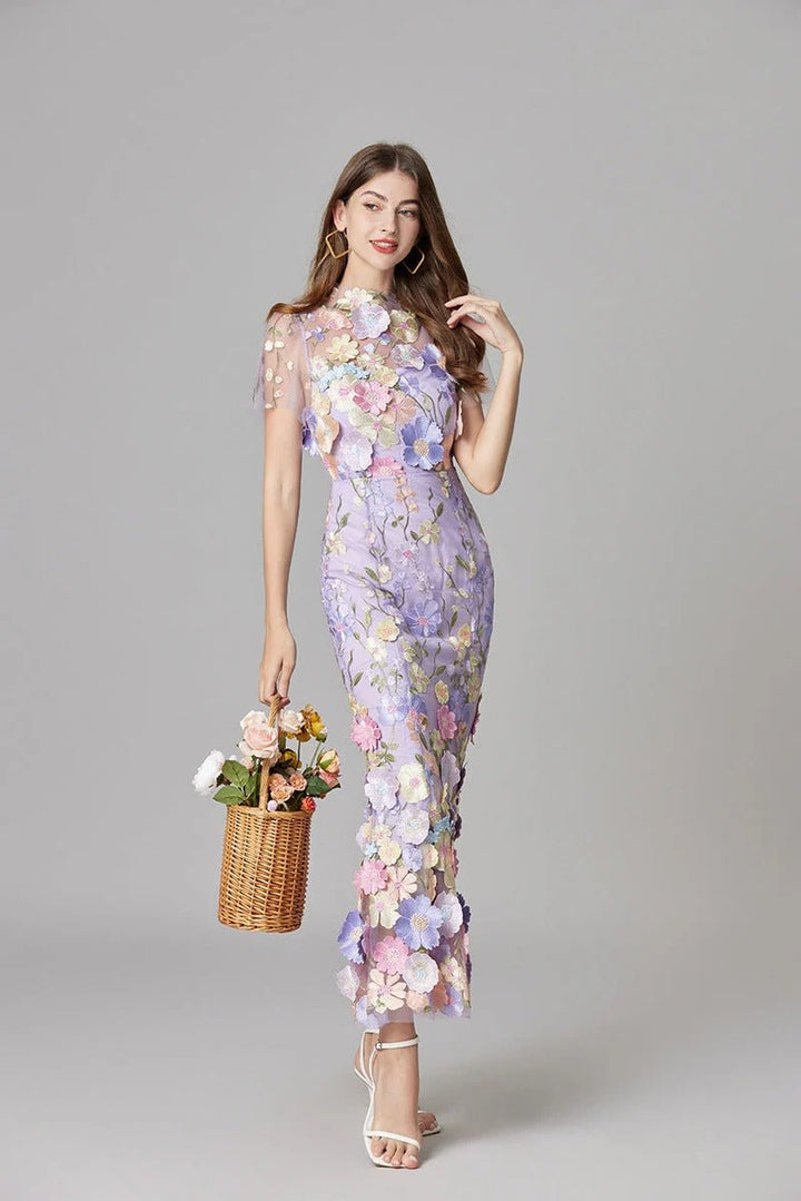 Flowing hemline of a women's elegant sleeveless maxi dress with subtle 3D floral appliqué.