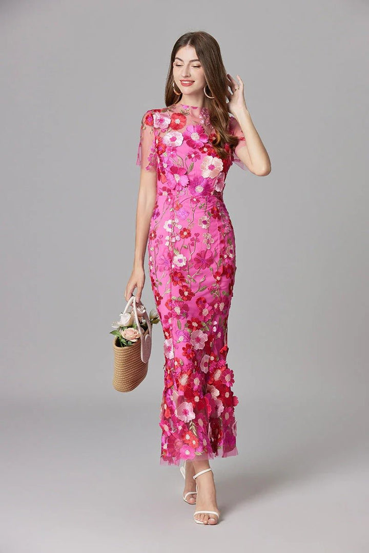 Full length view of a woman in a stunning 3D floral appliqué sleeveless maxi evening gown.