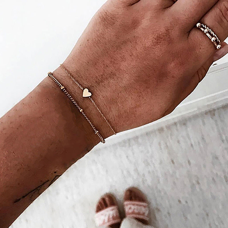 Women's adjustable gold bracelet with multiple white heart charms, elegant jewelry gift for her.