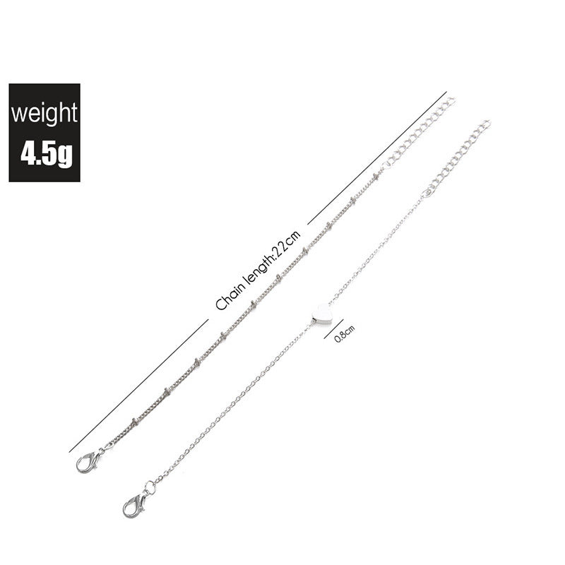 Delicate gold-tone women's charm bracelet featuring white heart pendants & adjustable chain.