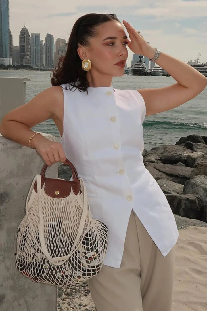 Sophisticated women's asymmetric sleeveless waistcoat, button front. Tailored vest for elegant business casual looks.