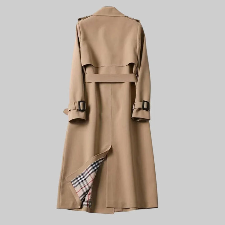 Sophisticated women's beige double-breasted trench coat, belted for a flattering silhouette, ideal outerwear.
