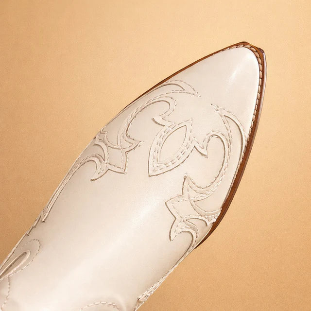 Elegant women's knee-high cowboy boots. Featuring detailed embroidered patterns & classic Western styling. Beige fashion boots.