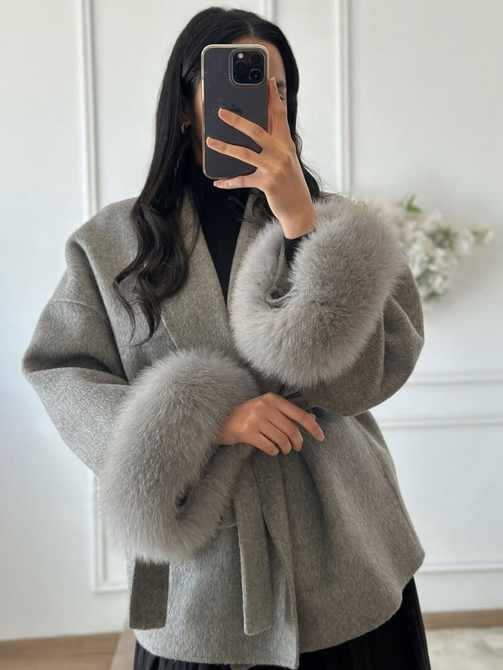 Chic women's wrap coat, featuring a tie waist belt & plush faux fur cuffs for luxury style.