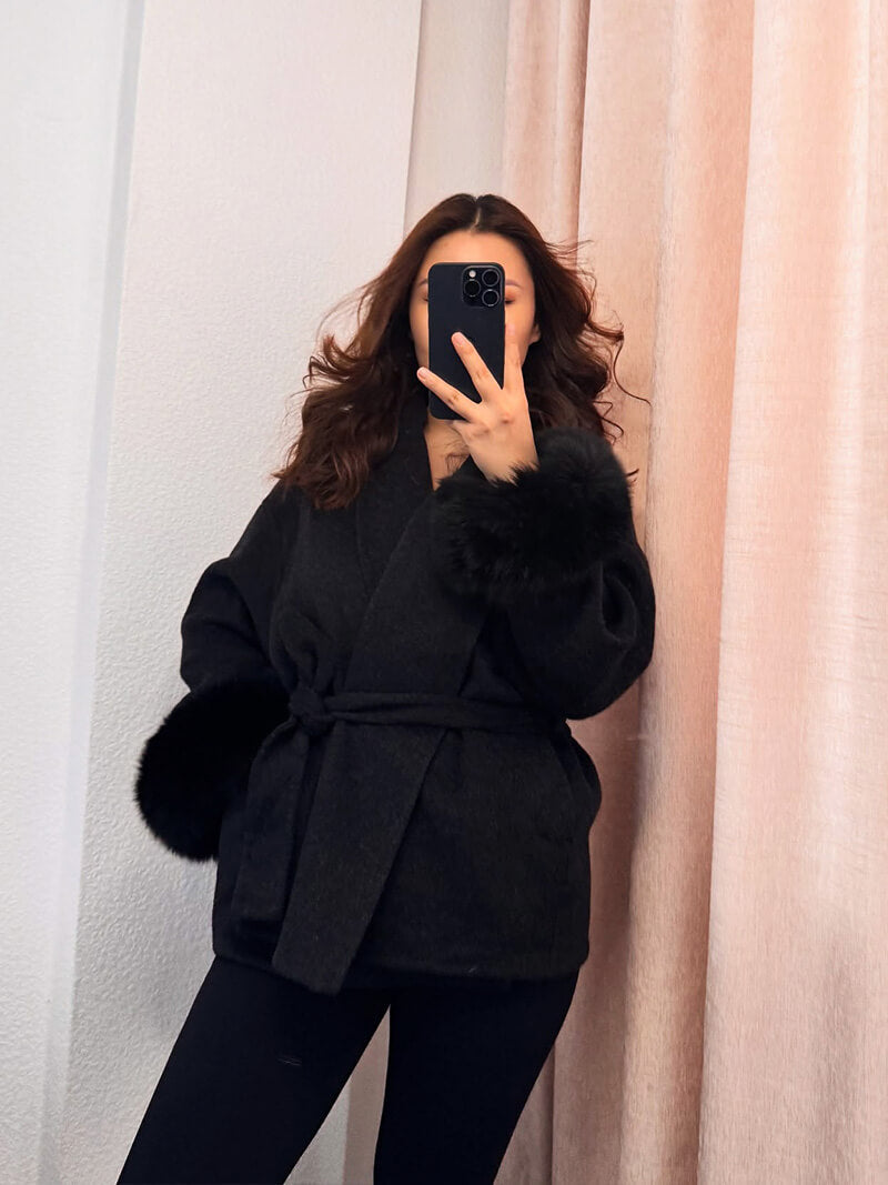 Stylish women's wrap coat with a flattering belt, luxurious faux fur cuffs, and a cozy fit.