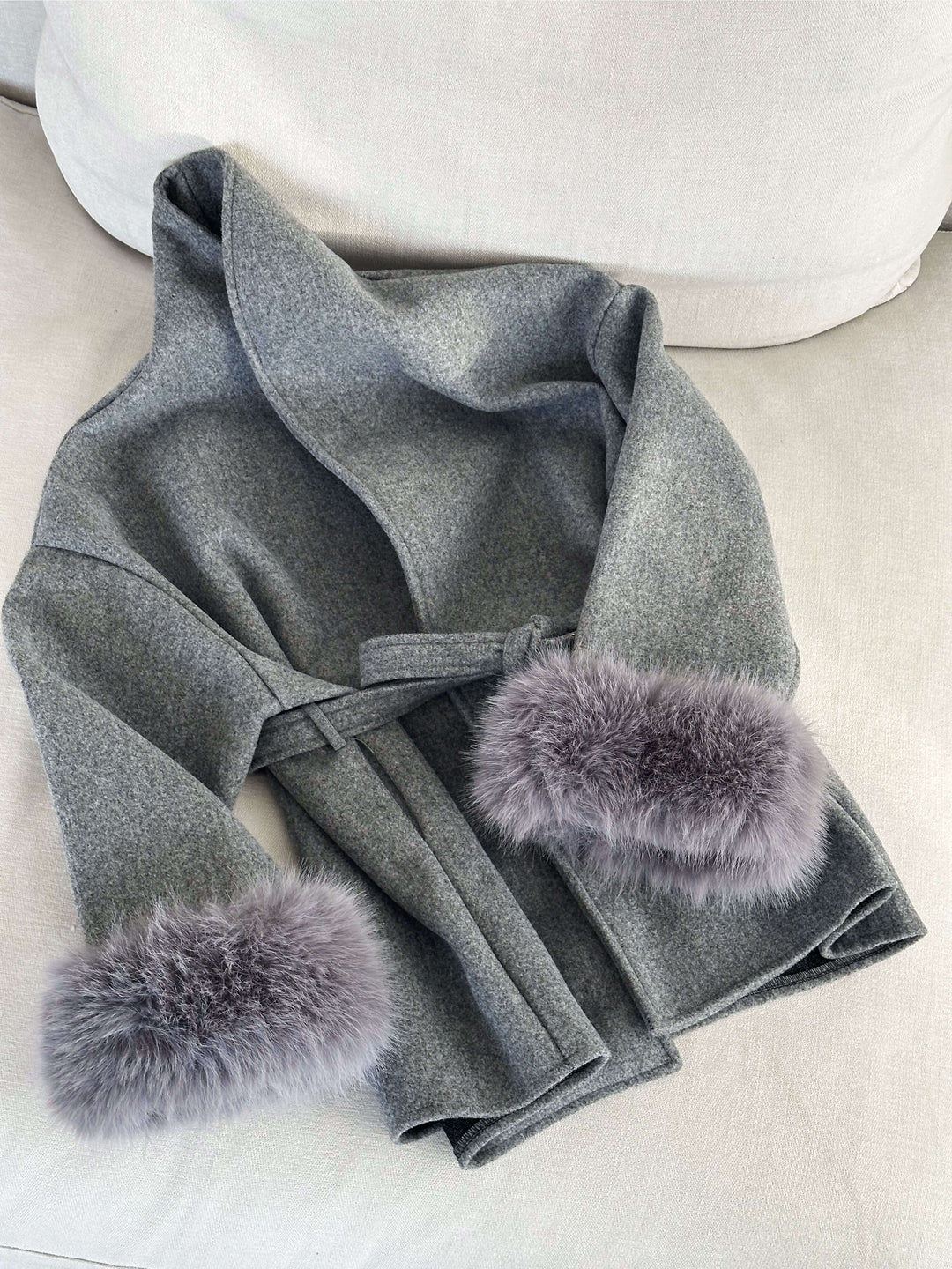 Stylish women's jacket: a wrap coat with a flattering belt and exquisite faux fur cuffs.