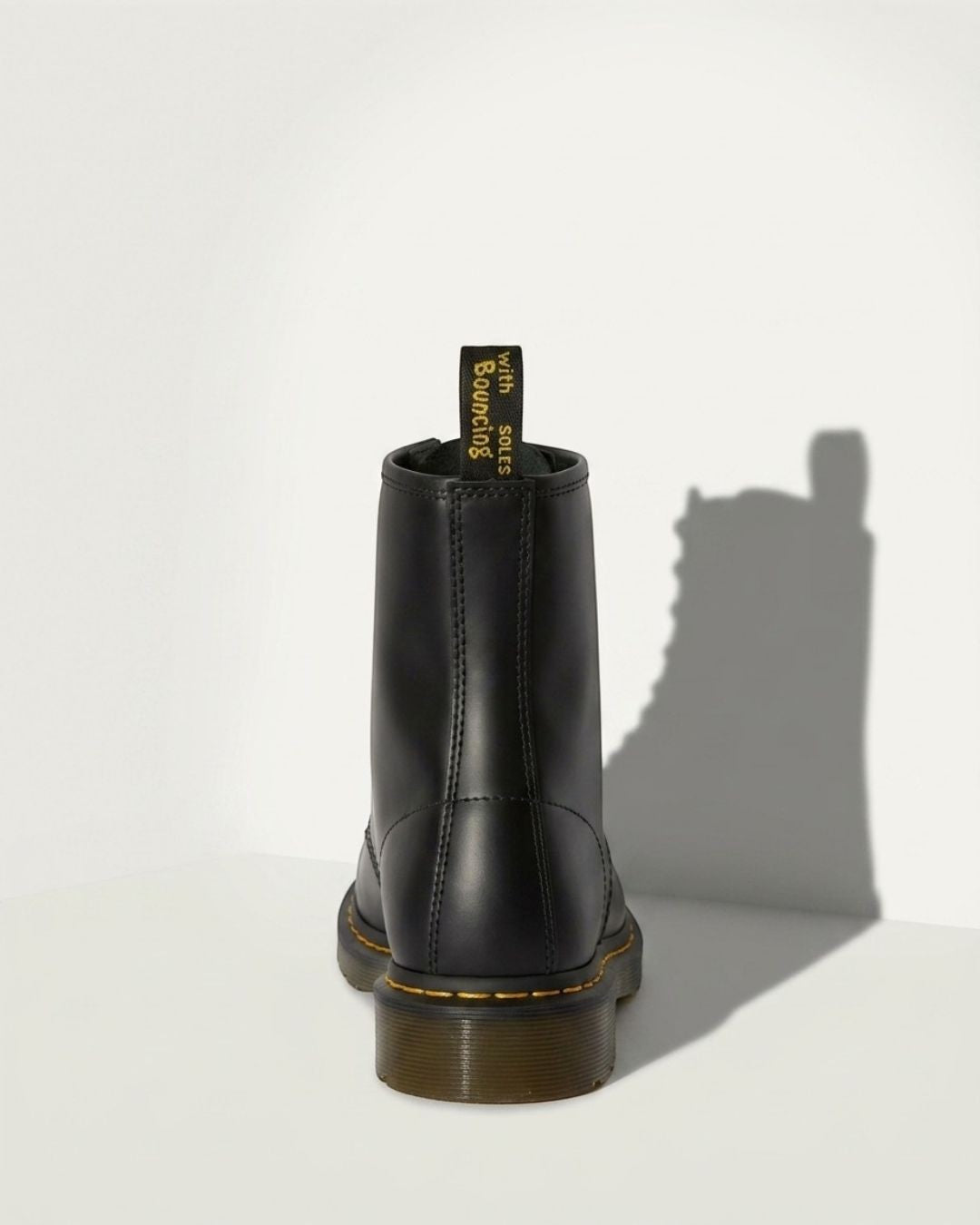Black faux leather women's combat boots, lace-up ankle style with chunky sole for edgy motorcycle fashion.