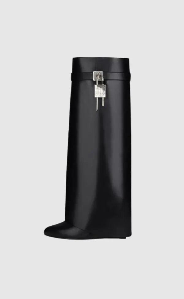 Statement women's black glossy knee-high boots with unique sculptural wedge heel, modern design.