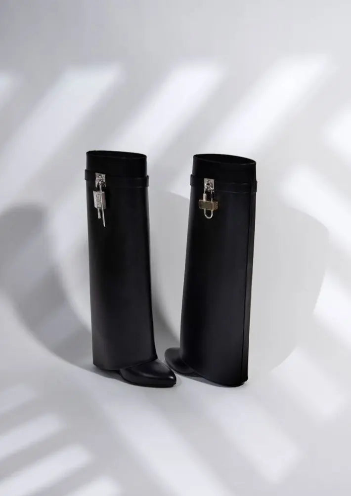 Chic women's black glossy knee-high boots with a comfortable sculptural wedge, ideal for winter fashion.