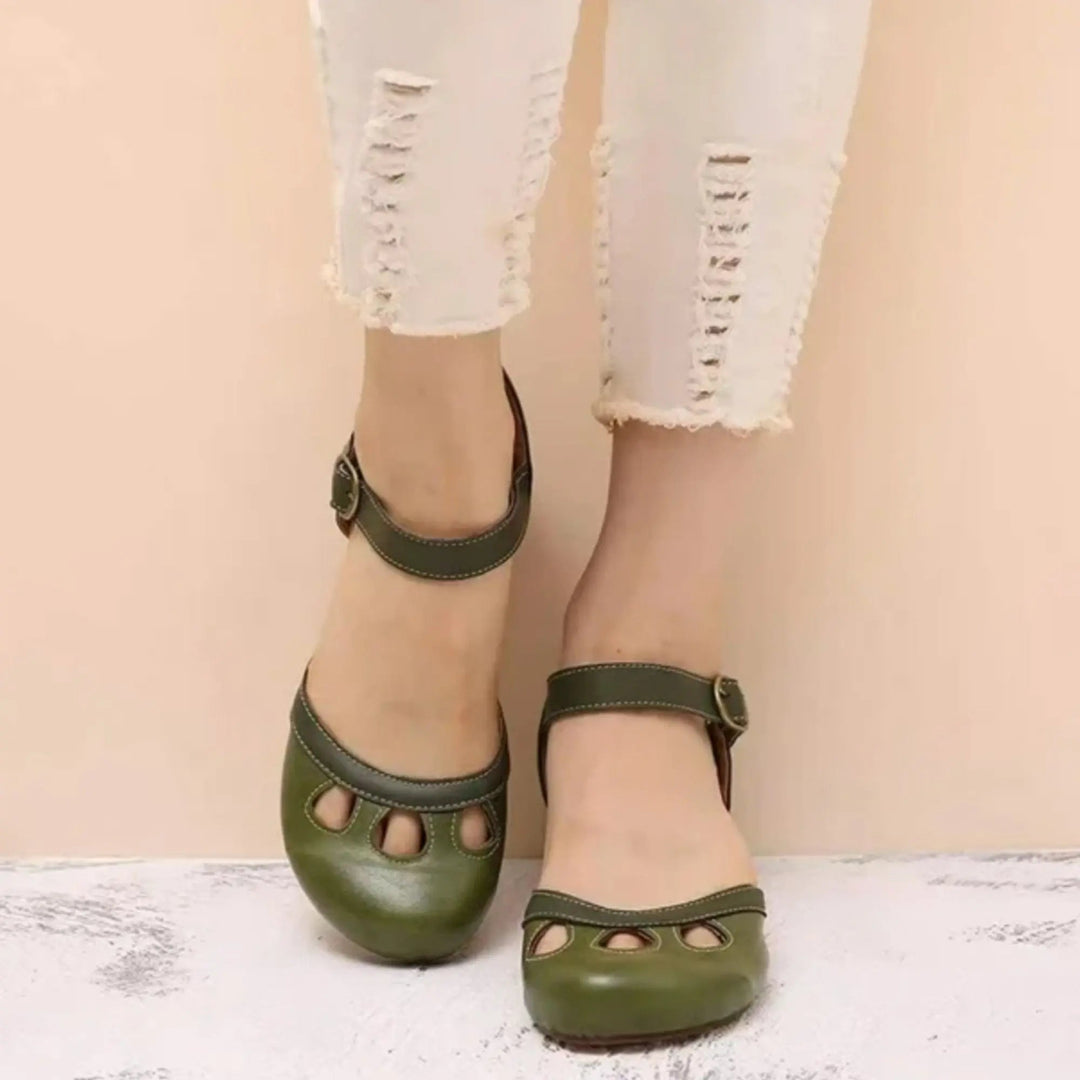 Women's black Mary Jane flats with ankle strap, charming cutout detail & rounded toe, perfect for vintage casual style.