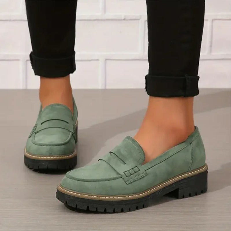 Black platform loafers for women with a chic vamp strap and a bold, comfortable chunky sole.