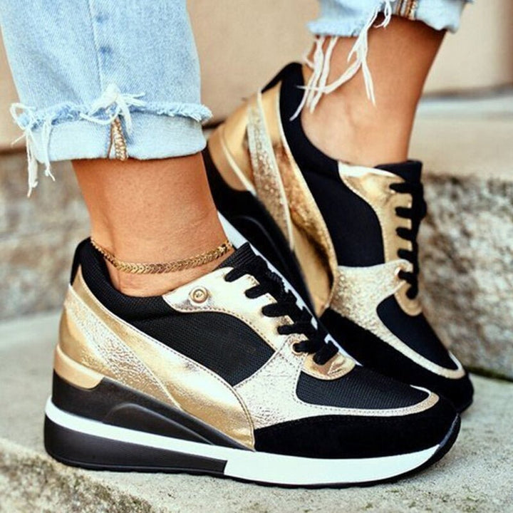 Women's black platform sneakers with gold metallic accents, comfortable street style fashion footwear.