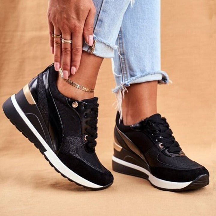 Black platform sneakers for women with stylish gold metallic accents, perfect for street style fashion.