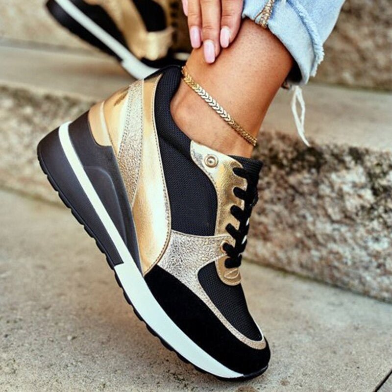 Chic women's black platform sneakers with gold details, offering trendy style & everyday comfort.