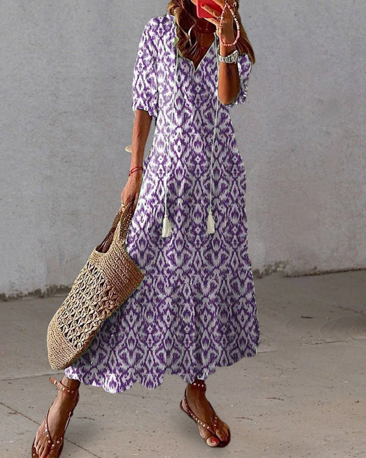 V-neck ikat print midi dress for women, featuring stylish tassels. Casual, flowy bohemian style summer wear.