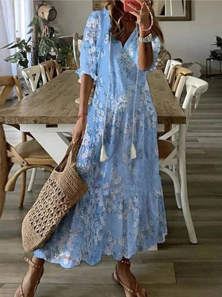 Flowy women's boho midi dress, ikat print V-neck with tassels. Comfortable casual summer resort wear.