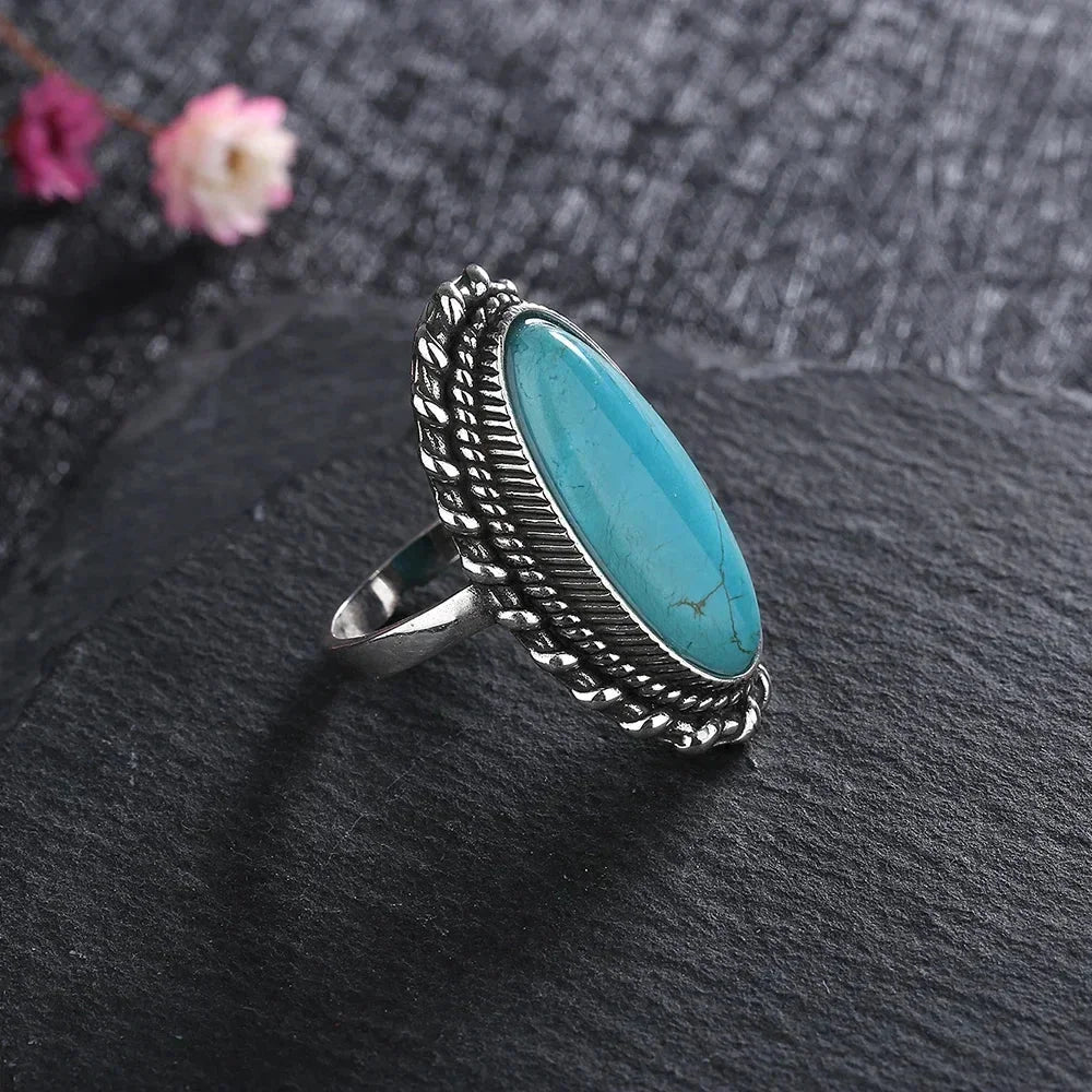 Unique women's statement ring: an oval turquoise gemstone set in a handcrafted braided silver-tone design.