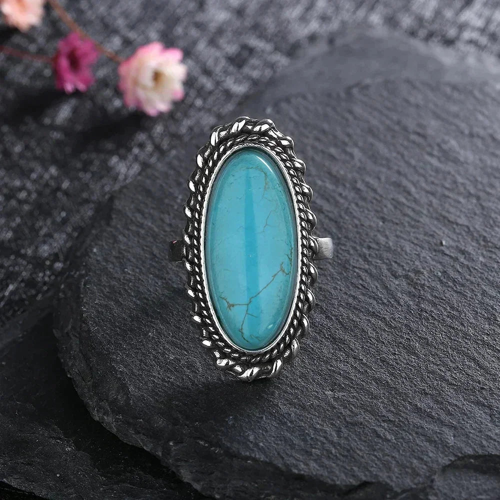 Elegant women's oval turquoise boho ring. Features intricate braided silver-tone detailing for a stylish look.