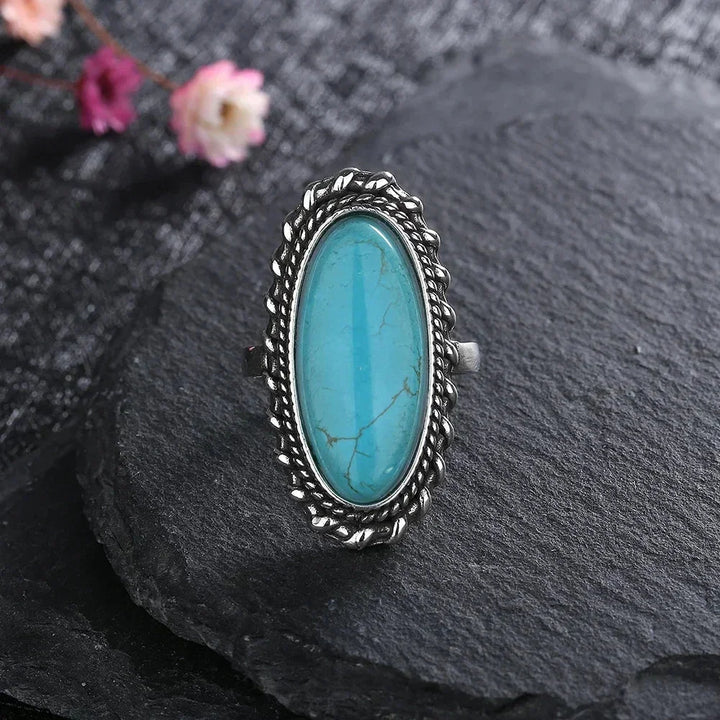 Elegant women's oval turquoise boho ring. Features intricate braided silver-tone detailing for a stylish look.