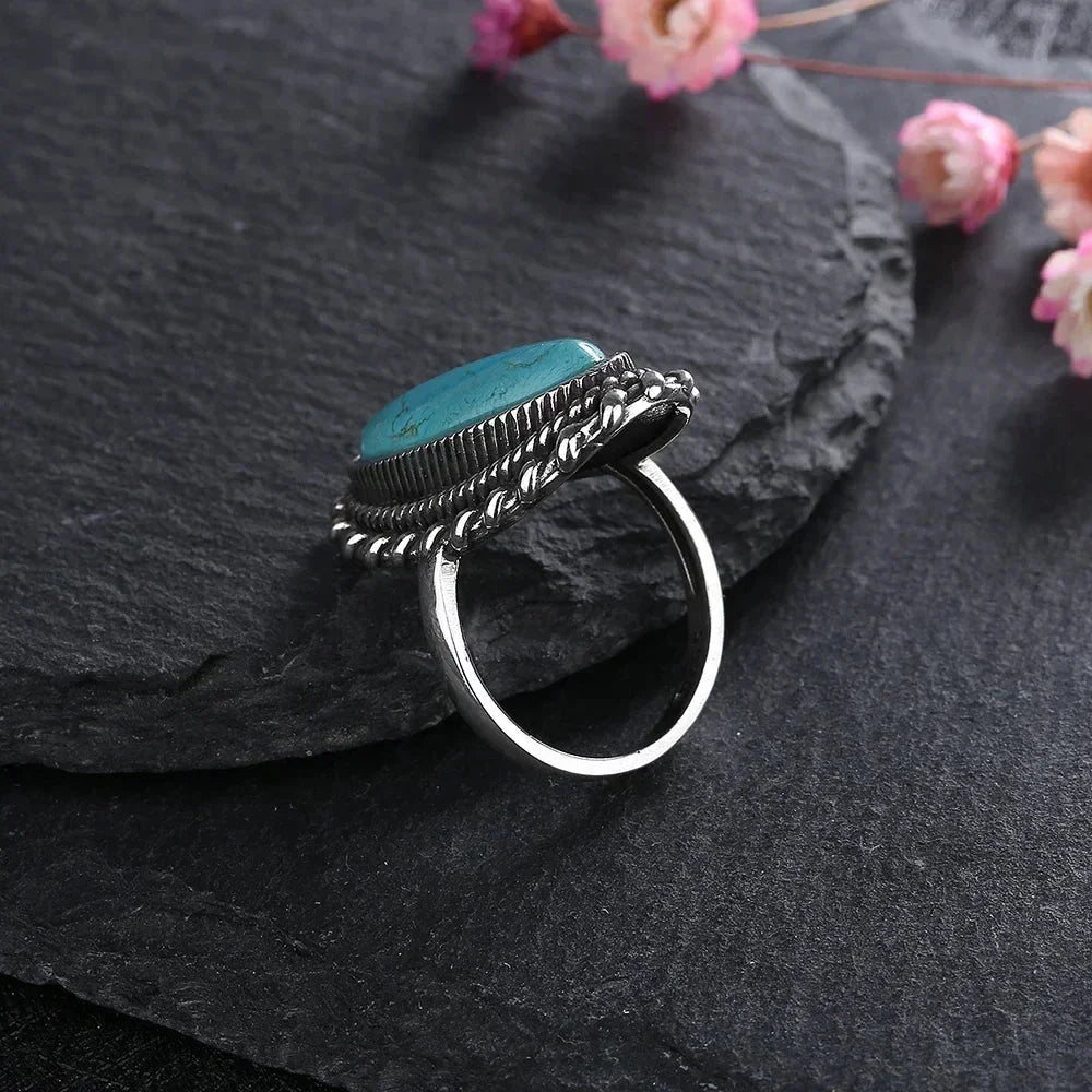 Stunning women's gemstone jewelry, an oval turquoise ring with a chic braided silver-tone setting.