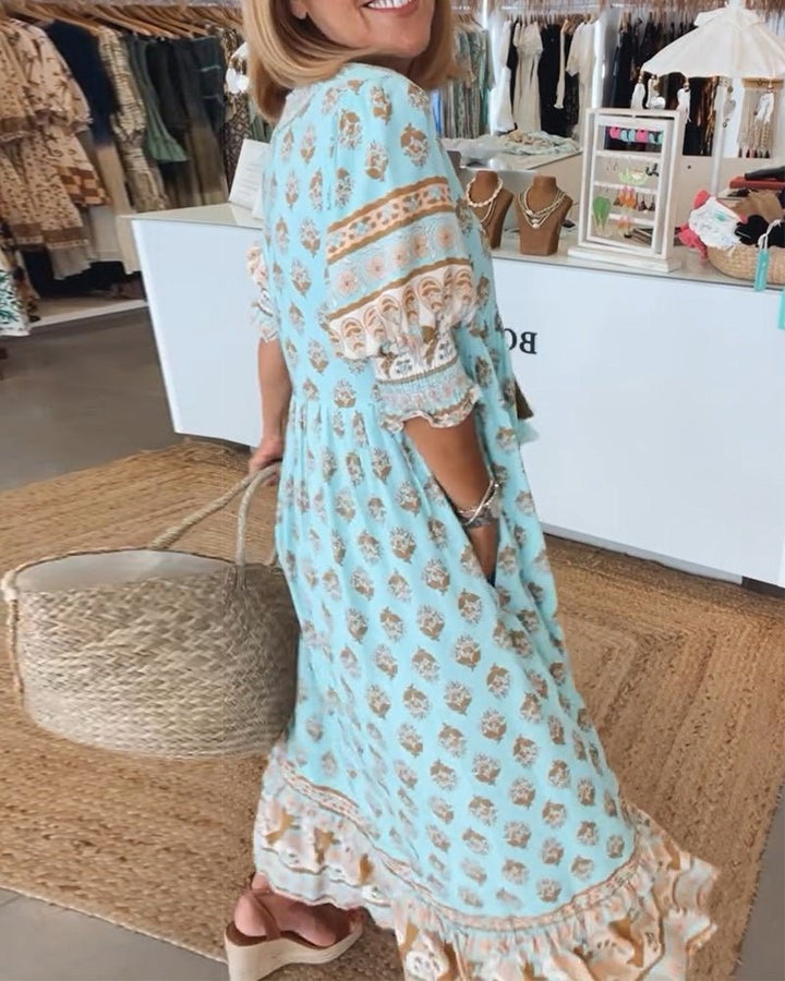 Flowy bohemian chic midi dress for women, featuring a vibrant print and stylish tassel tie detail.