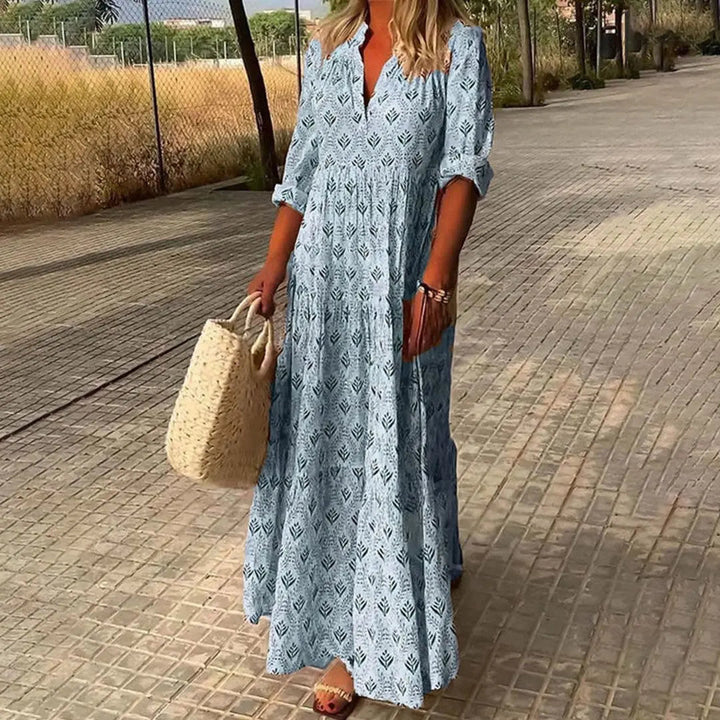 Flowy bohemian printed maxi dress for women, featuring a V-neck & roll-up sleeves. Ideal for casual or vacation wear.