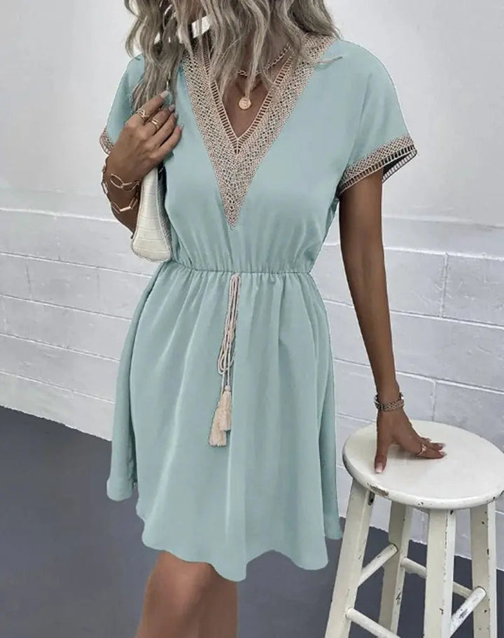 Casual bohemian short sleeve midi dress with V-neck and tie waist. Versatile & comfortable summer wear.