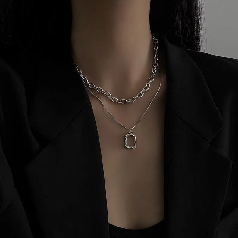 Gold statement chunky chain necklace for women with a distinctive rectangular pendant. Bold fashion jewelry accessory.