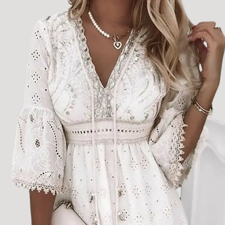 Women's summer mini dress with delicate embroidery, V-neckline, and flowy flared sleeves. Breezy boho style.