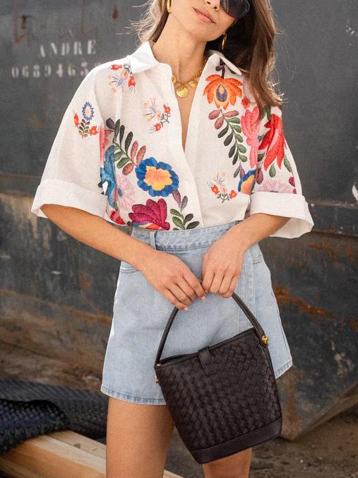 Comfortable women's button-front collared blouse featuring a unique print. Short sleeve, great for any season.