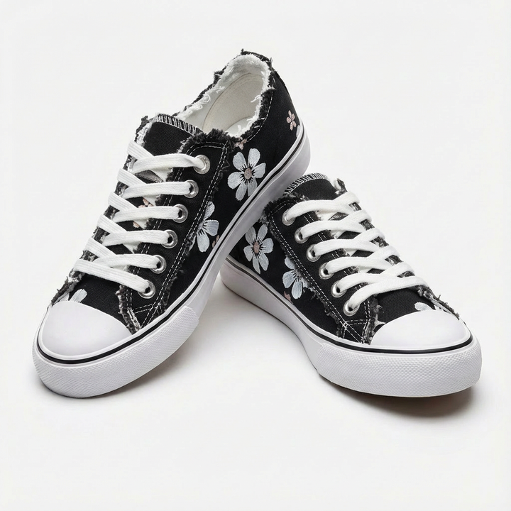 Embroidered women's casual sneakers showcasing intricate floral patterns & a chic frayed edge. Stylish everyday footwear.