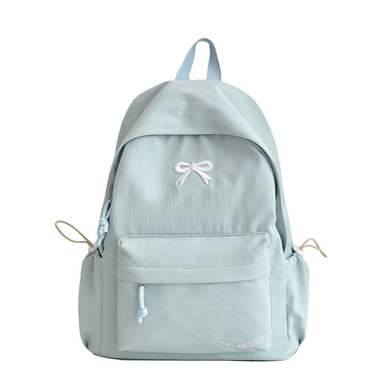 Versatile women's casual backpack with a delicate bow-embossed texture, suitable for school, work, or travel.