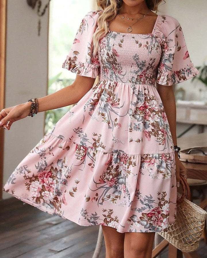 Feminine floral print mini dress with smocked detail, short length, and stylish puff sleeves. Summer fashion.
