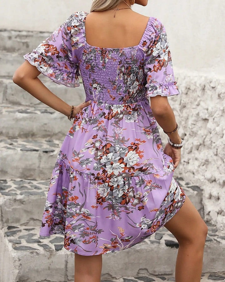 Stylish women's summer mini dress: colorful floral print, smocked bodice, and charming puff sleeves.