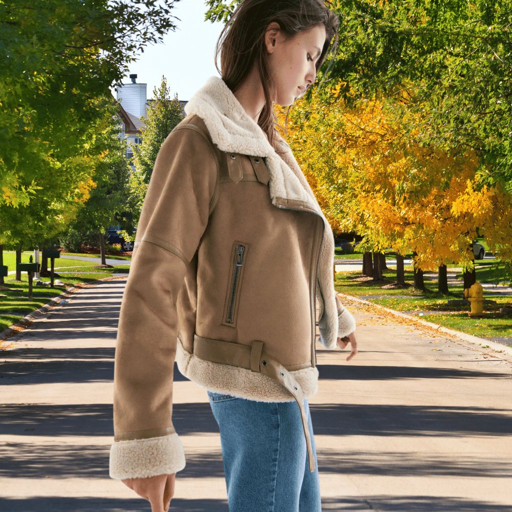 Detailed view of the collar and faux shearling lining of an aviator bomber fashion jacket.
