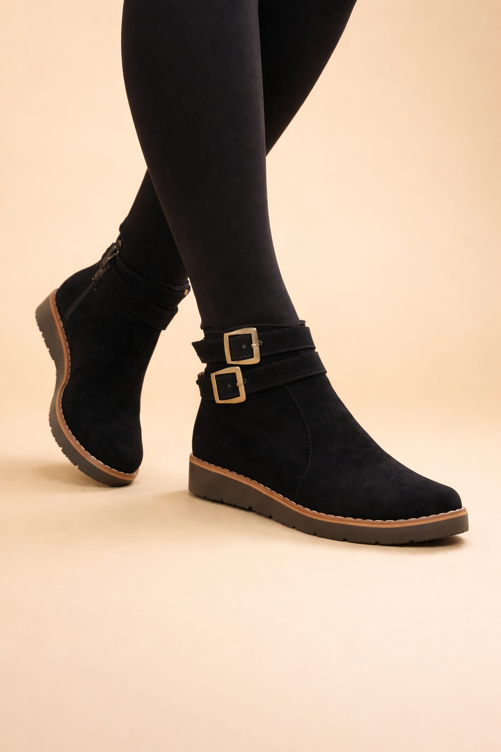 Close-up of black women's structured ankle boots, highlighting the buckle and sophisticated design for winter.
