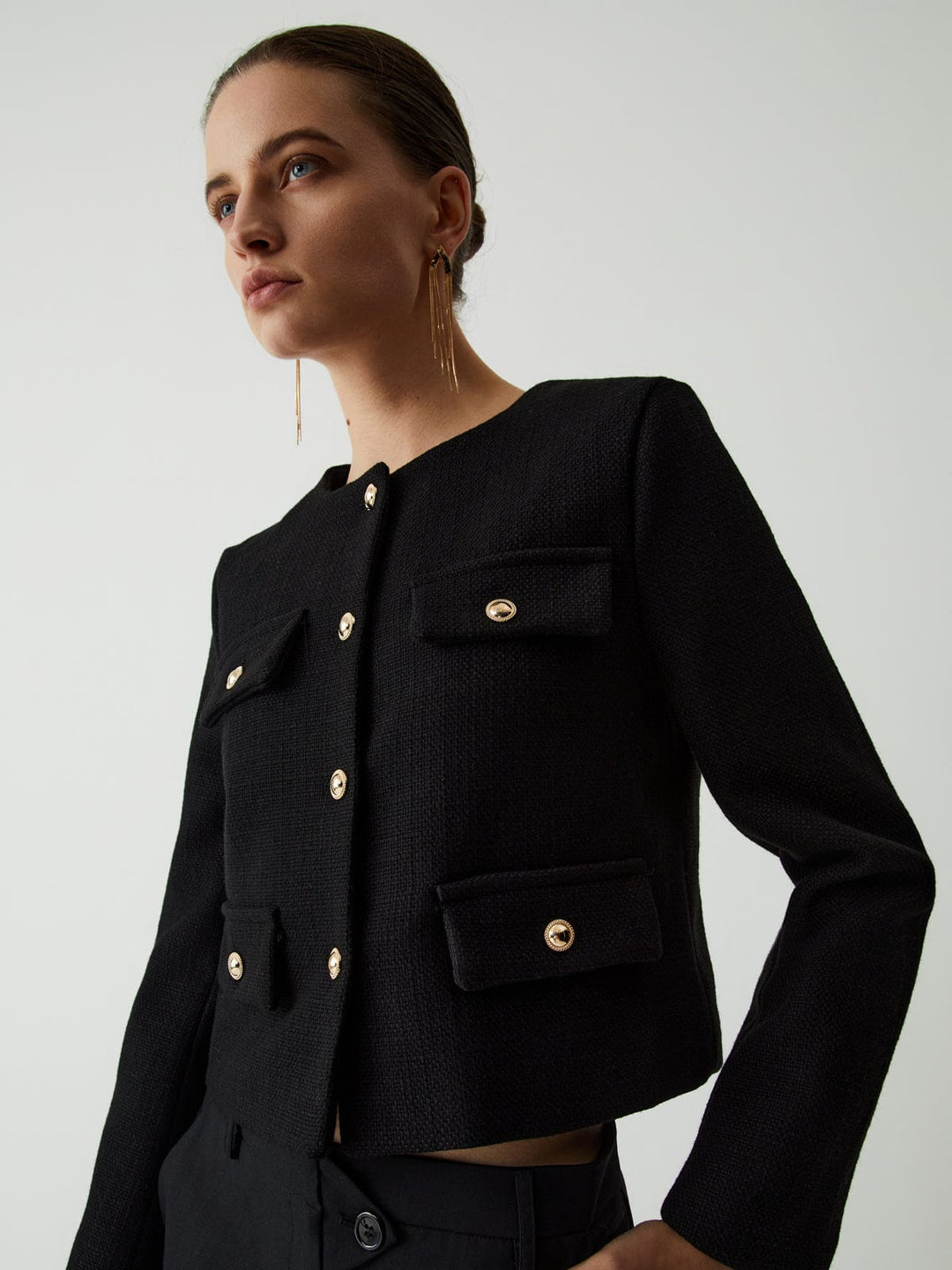 Stylish women's cropped jacket featuring striking gold buttons and functional pockets, tailored fit.