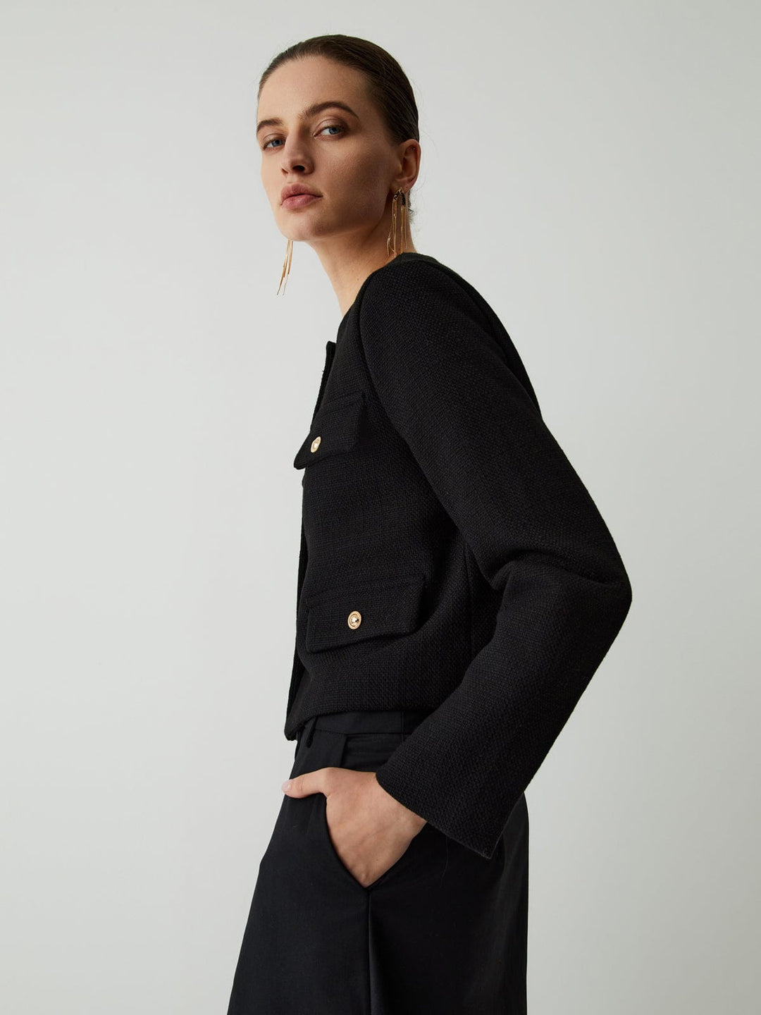 Modern women's cropped jacket with gold buttons, adding a touch of chic to any smart casual outfit.