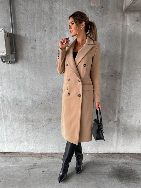 Model wearing a chic women's double-breasted winter jacket. Elegant outerwear in classic style.